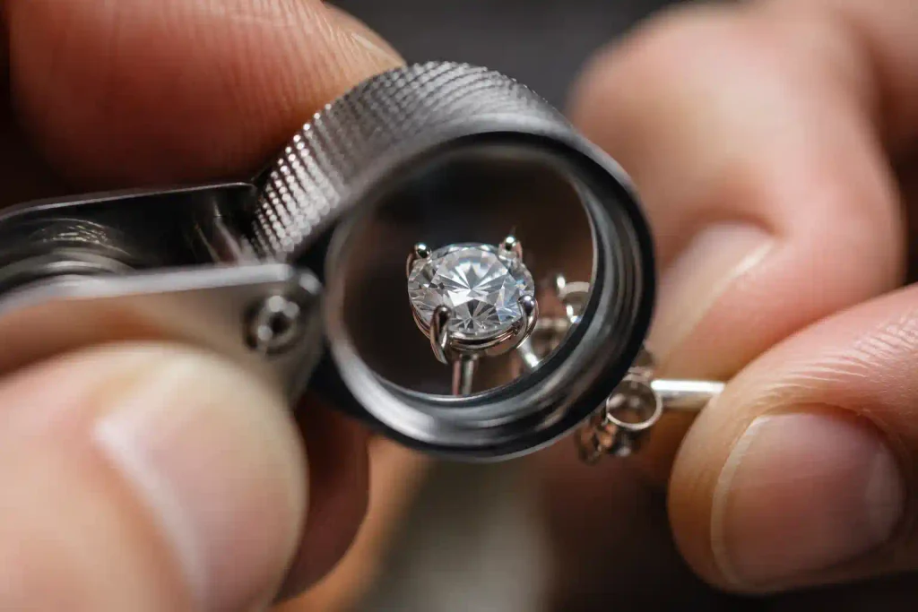 Jeweler inspecting diamond earring setting with a loupe